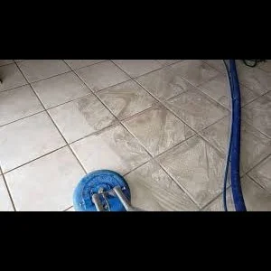 Professional tile floor being cleaned with blue equipment and hose